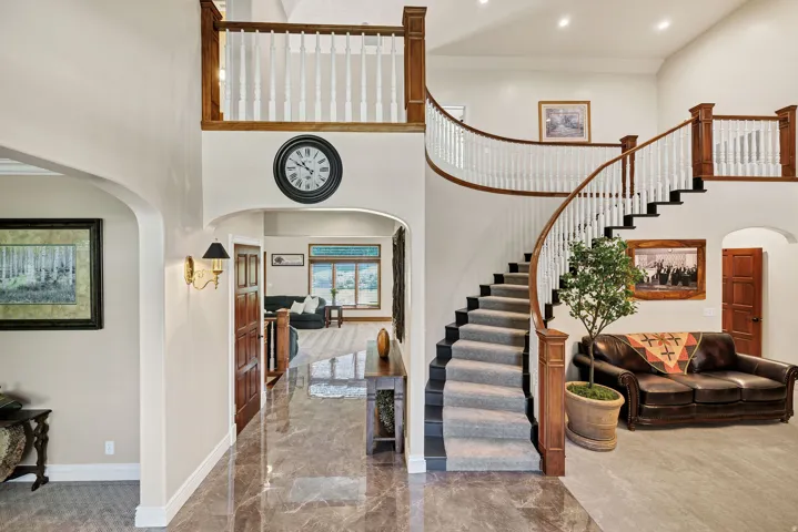 Two-story foyer featuring a grand curved staircase with wood-finish handrails and white balusters