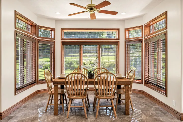 Bay window with wood-finish trim, a ceiling fan, recessed lighting, and tile flooring
