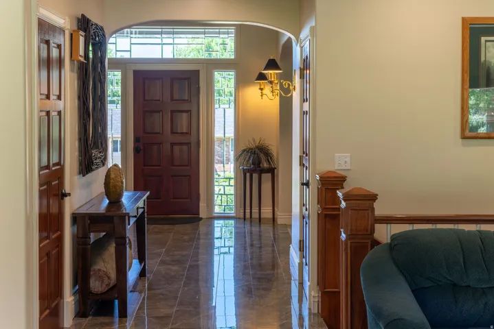 Arched entryway leading to a paneled front door with sidelights and transom window