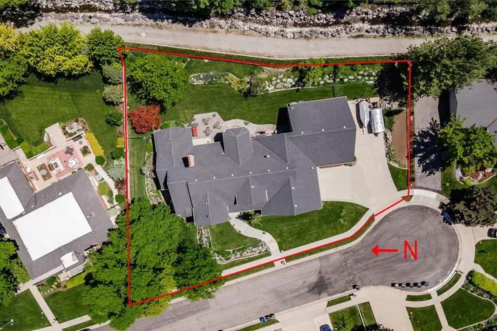 Expansive property with a multi-level structure, a dark shingle roof, and a paved driveway