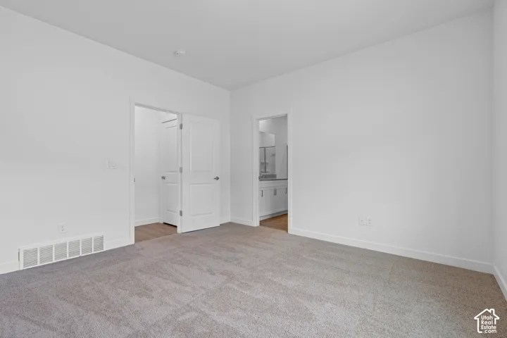 Plush carpet flooring, neutral paint palette, and white interior doors