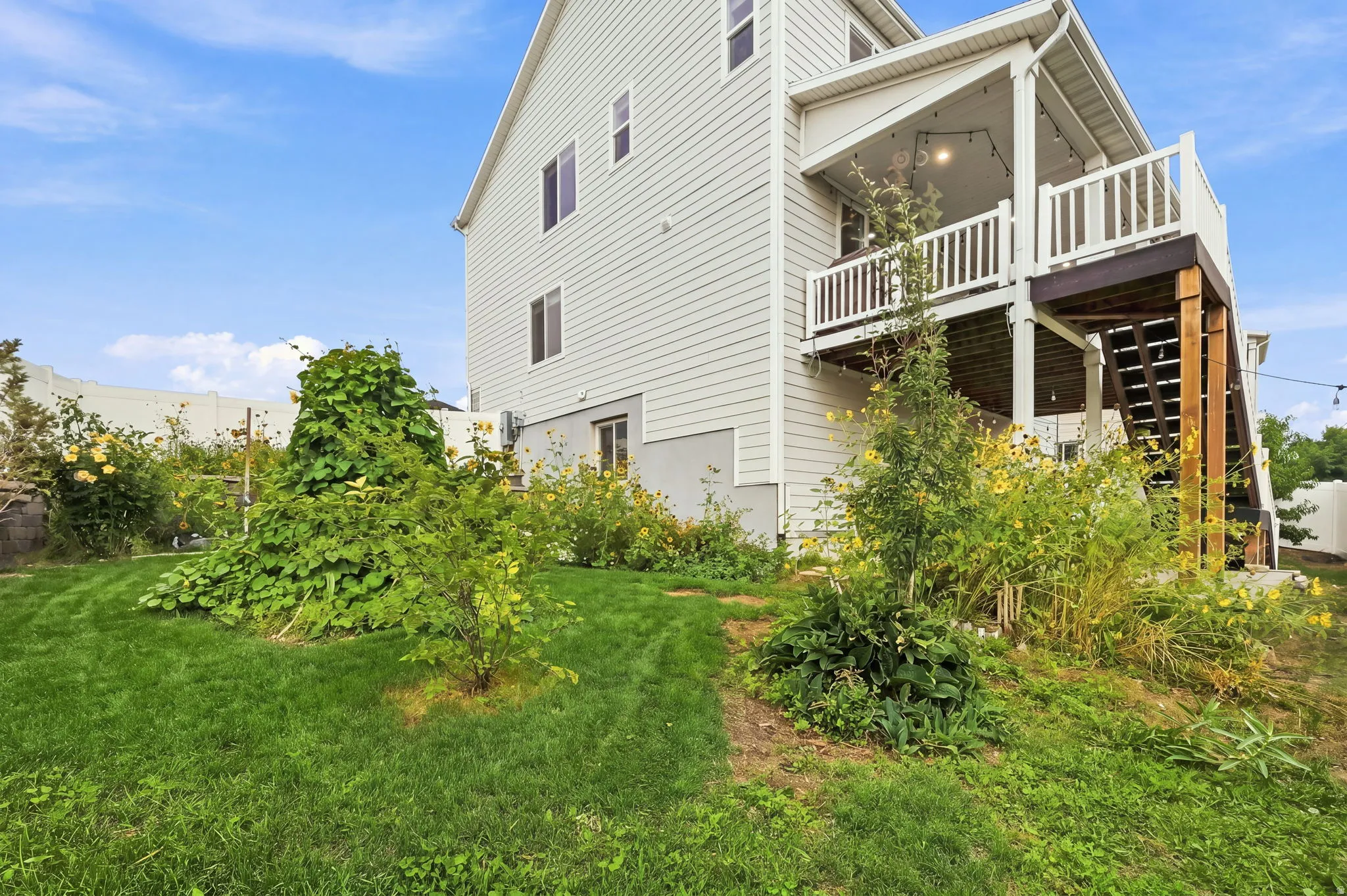 Exterior featuring light-colored horizontal siding and a covered deck with white railings