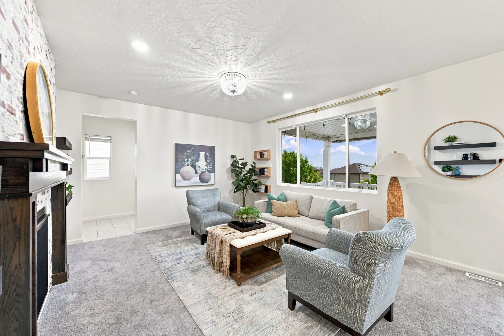 Spacious living area featuring a dark wood finish fireplace with a tiled surround, recessed lighting, and a contemporary chandelier