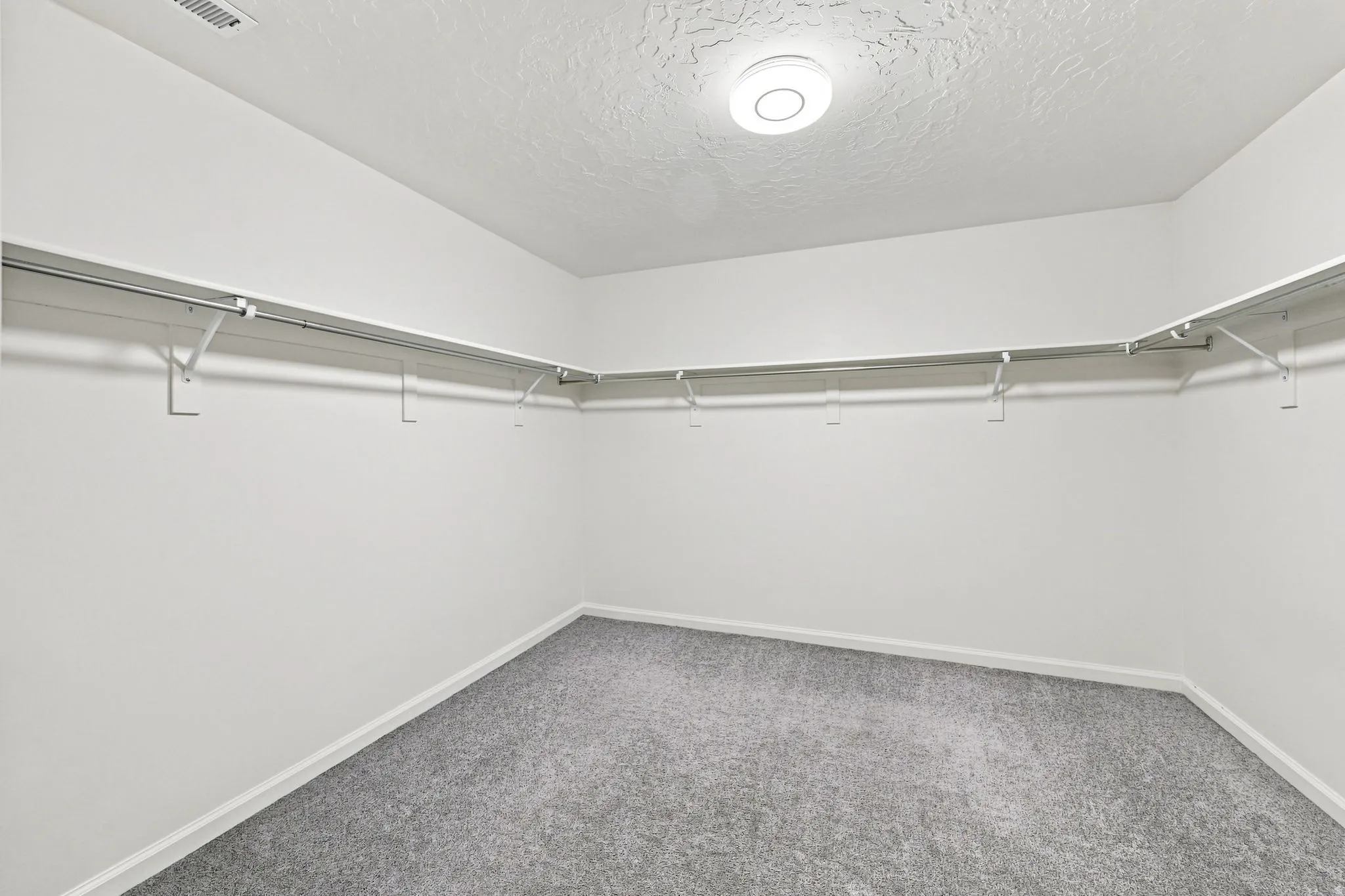 Wall-to-wall carpeting with built-in shelving and hanging rods