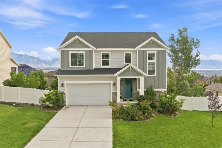 Two-story residence with a two-car garage, stone accents, and a covered entry