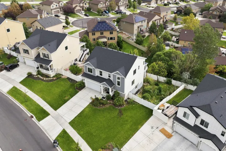 Two-story residence featuring a covered porch, attached two-car garage, and established front landscaping