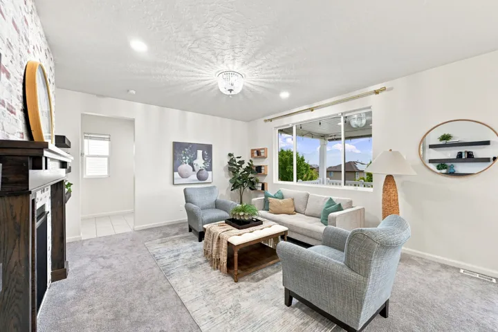 Spacious living area featuring a dark wood finish fireplace with a tiled surround, recessed lighting, and a contemporary chandelier