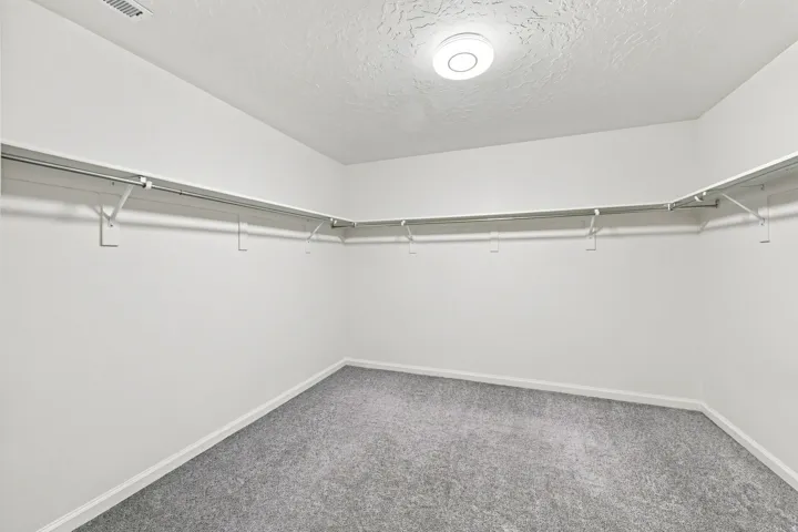 Wall-to-wall carpeting with built-in shelving and hanging rods