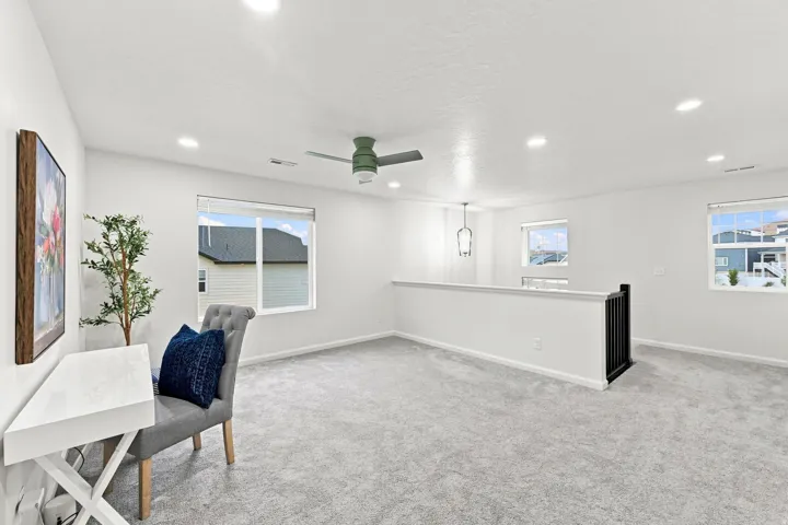 Loft space featuring recessed lighting, a ceiling fan, multiple windows, and carpet flooring