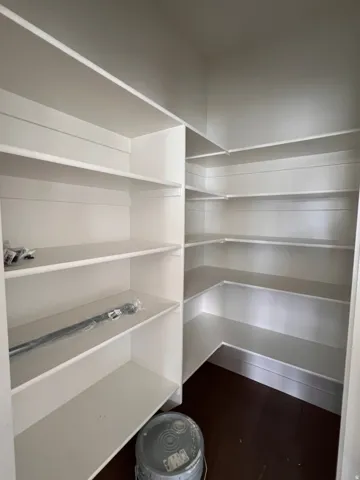 White built-in shelving, dark wood-finish flooring