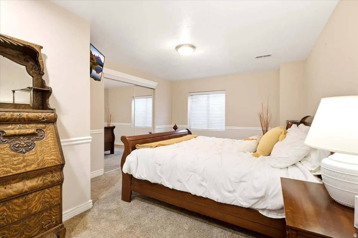 Neutral wall tones, carpeted flooring, window with blinds, and white trim molding