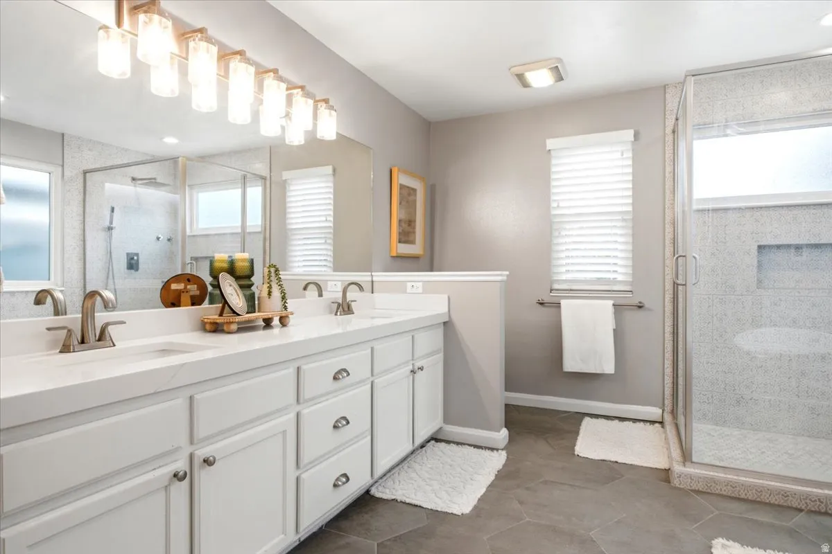 Dual vanity with white cabinetry, brushed nickel hardware, and a quartz countertop
