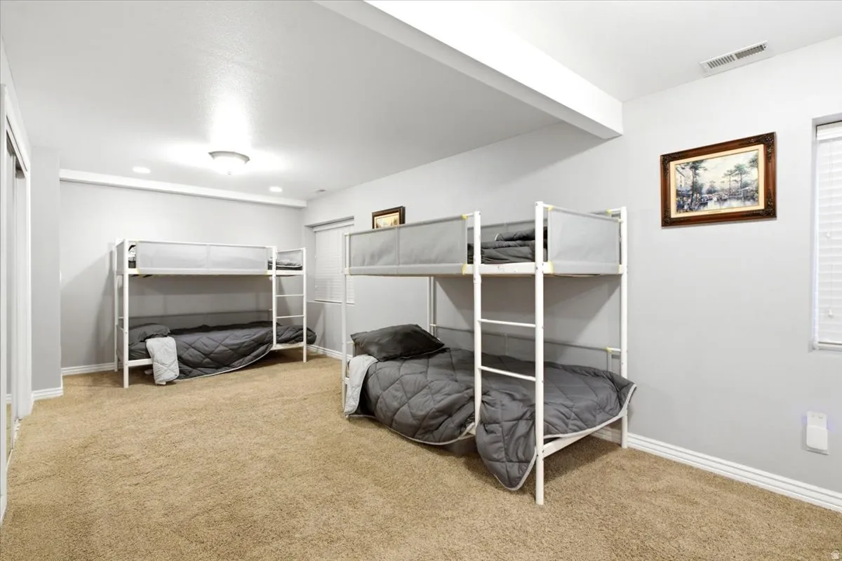 Carpeted room with light gray walls, white trim, and a window with blinds