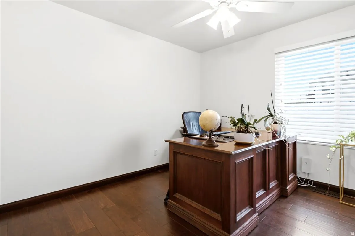 Wood-finish flooring, white walls, and a ceiling fan with integrated lighting