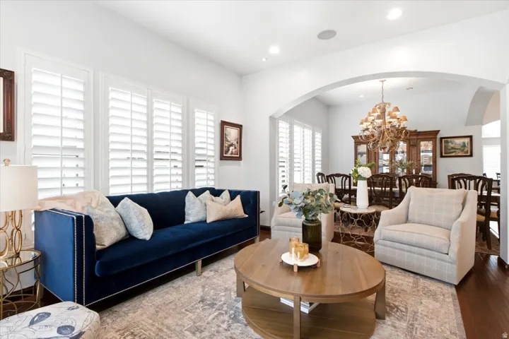 Hardwood flooring, plantation shutters, recessed lighting, and an arched entryway