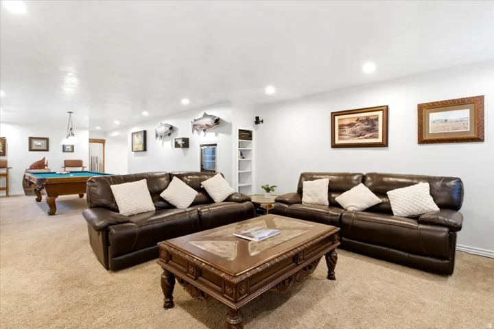 Recessed ceiling lighting, built-in shelving, and a prominent billiard table