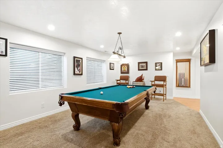 Carpeted recreation room with recessed lighting, two and windows with horizontal blinds