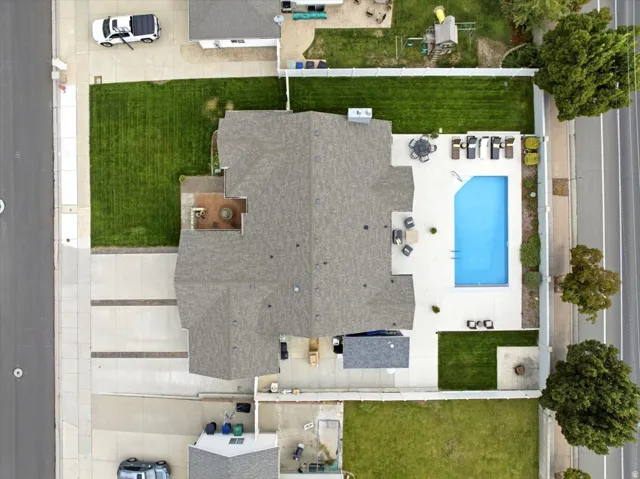 Expansive property featuring a large swimming pool, paved patio areas, and a spacious lawn