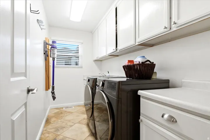 White cabinetry with brushed nickel hardware, light-toned countertop space, and tiled flooring