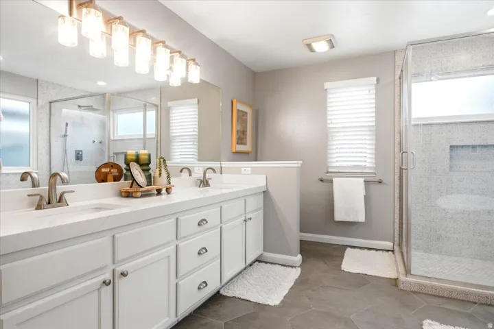 Dual vanity with white cabinetry, brushed nickel hardware, and a quartz countertop