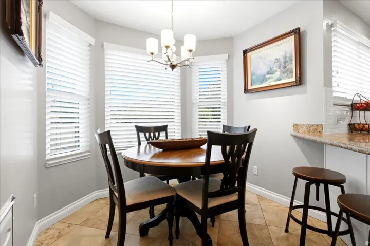 Dining area with bay windows, tile flooring, and a multi-light chandelier