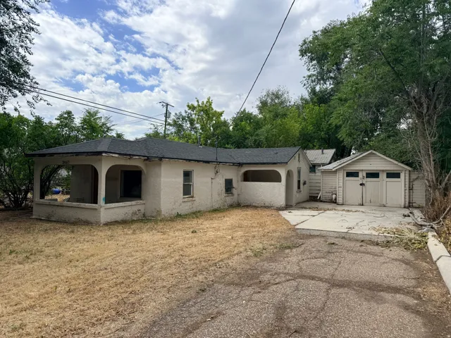 Property exterior featuring a covered porch, stucco finish, and a detached two-car garage