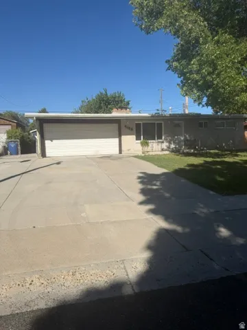Single-story residence featuring a two-car garage, concrete driveway, and front lawn