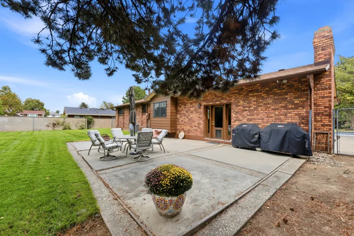 Expansive concrete patio with brick and siding exterior