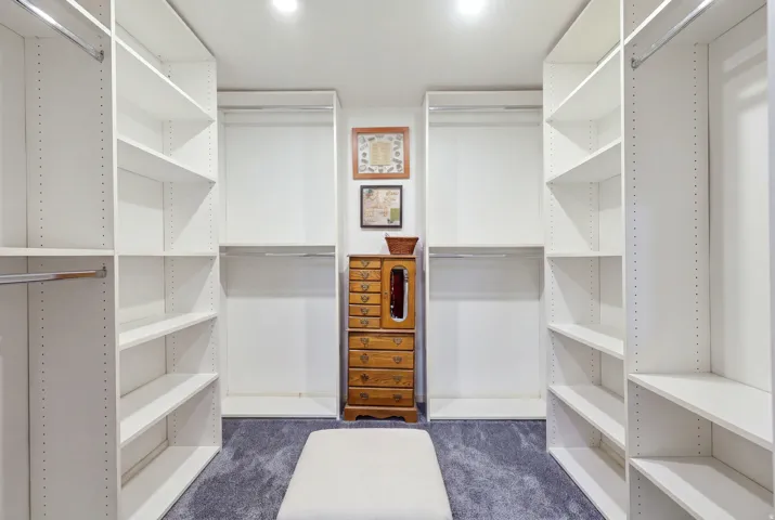 White custom closet system featuring adjustable shelving and integrated hanging rods