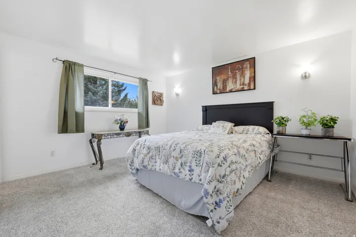 Upstairs Primary Bedroom, light-colored carpeting, white painted walls, and a large window with white trim