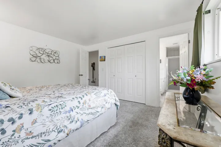 Upstairs Primary Bedroom. White walls with light gray carpeting, featuring a bi-fold closet and a window