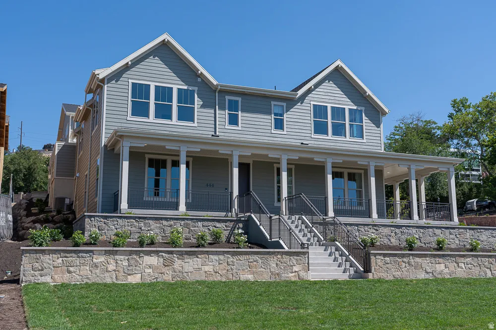 Two-story residence featuring light gray siding and white trim