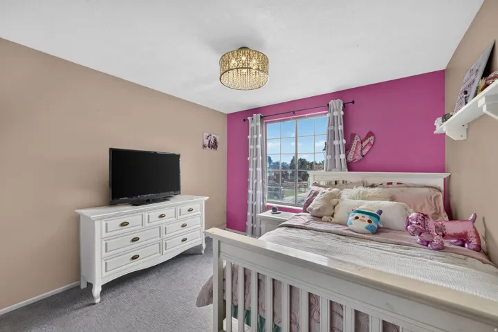 Recessed window with a white frame, overhead crystal chandelier, and carpet flooring