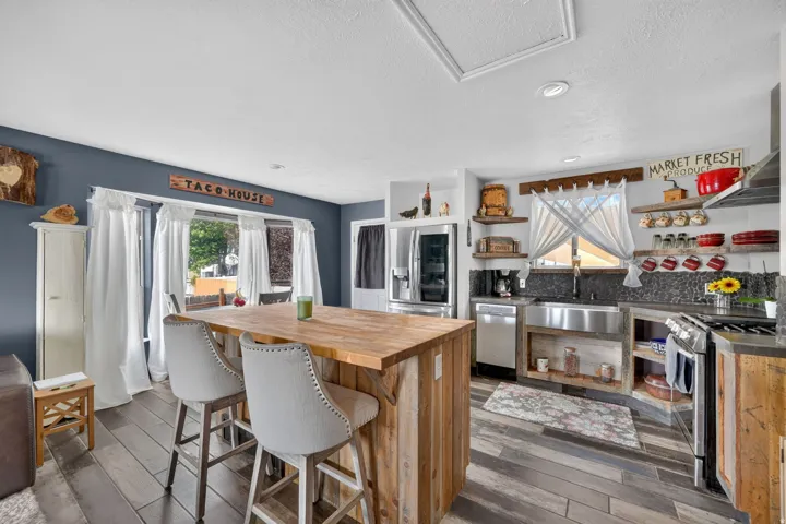 Wood-finish flooring throughout, with a large kitchen island featuring a wood countertop