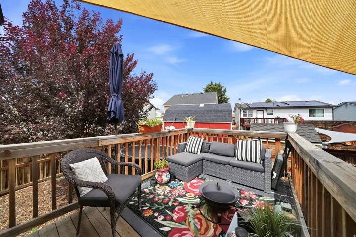 Expansive wood deck with a privacy screen and mature landscaping