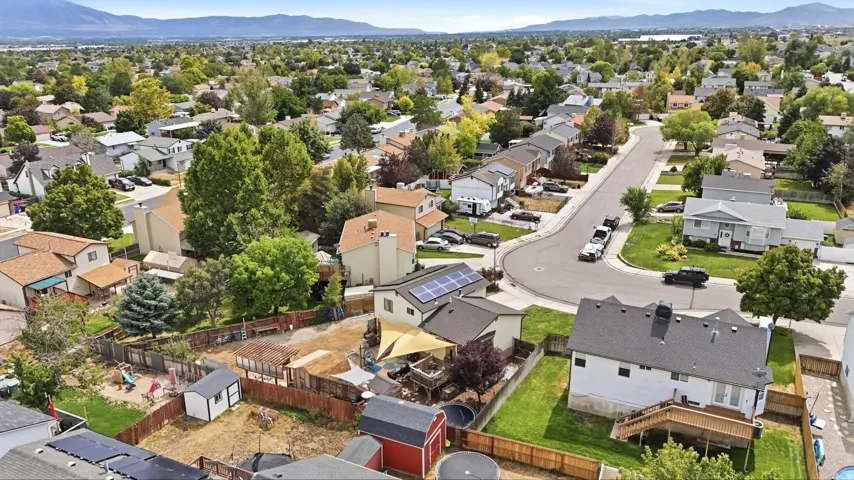 Residential neighborhood with established homes and mature trees, featuring a prominent mountain backdrop