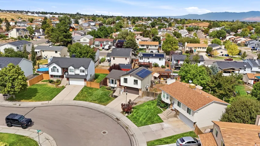 Residential neighborhood featuring a mix of single-family homes, mature landscaping, and a mountainous backdrop