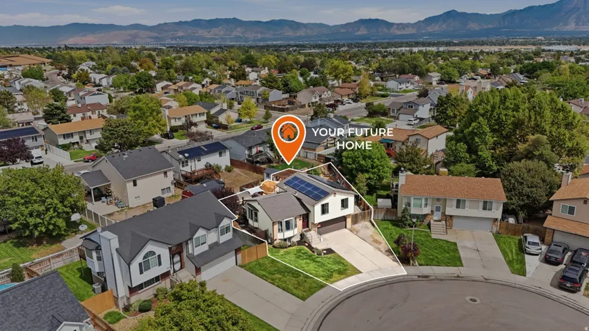 Residential property with solar panel installation, a two-car garage, and a paved driveway