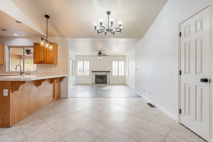 Kitchen featuring wood cabinetry, tile countertop, and a stainless steel sink with a gooseneck faucet