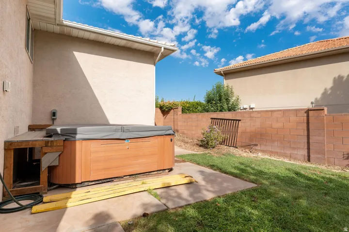 Private backyard featuring a built-in spa, concrete patio, and block wall fencing