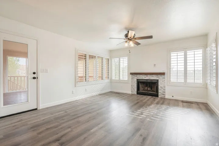 Wood-finish flooring, white walls, and a fireplace with a mosaic tile surround and wood mantel