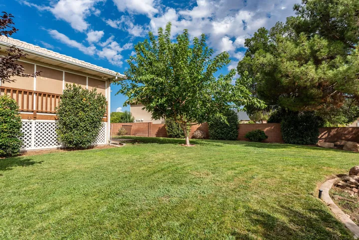 Expansive grassy lawn with mature trees and a brick perimeter wall
