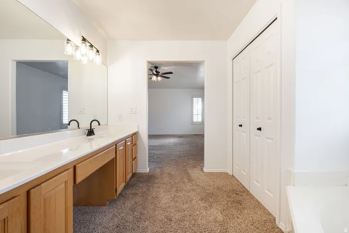 Dual vanity with light wood-finish cabinetry and white countertop