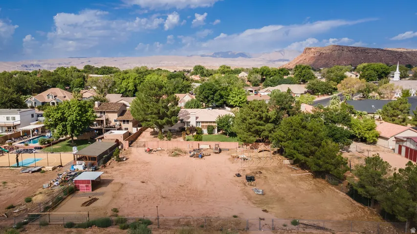 Expansive land parcel featuring open terrain, mature trees, and a distant mountain backdrop
