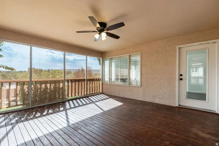 Spacious screened-in porch with wood-finish flooring