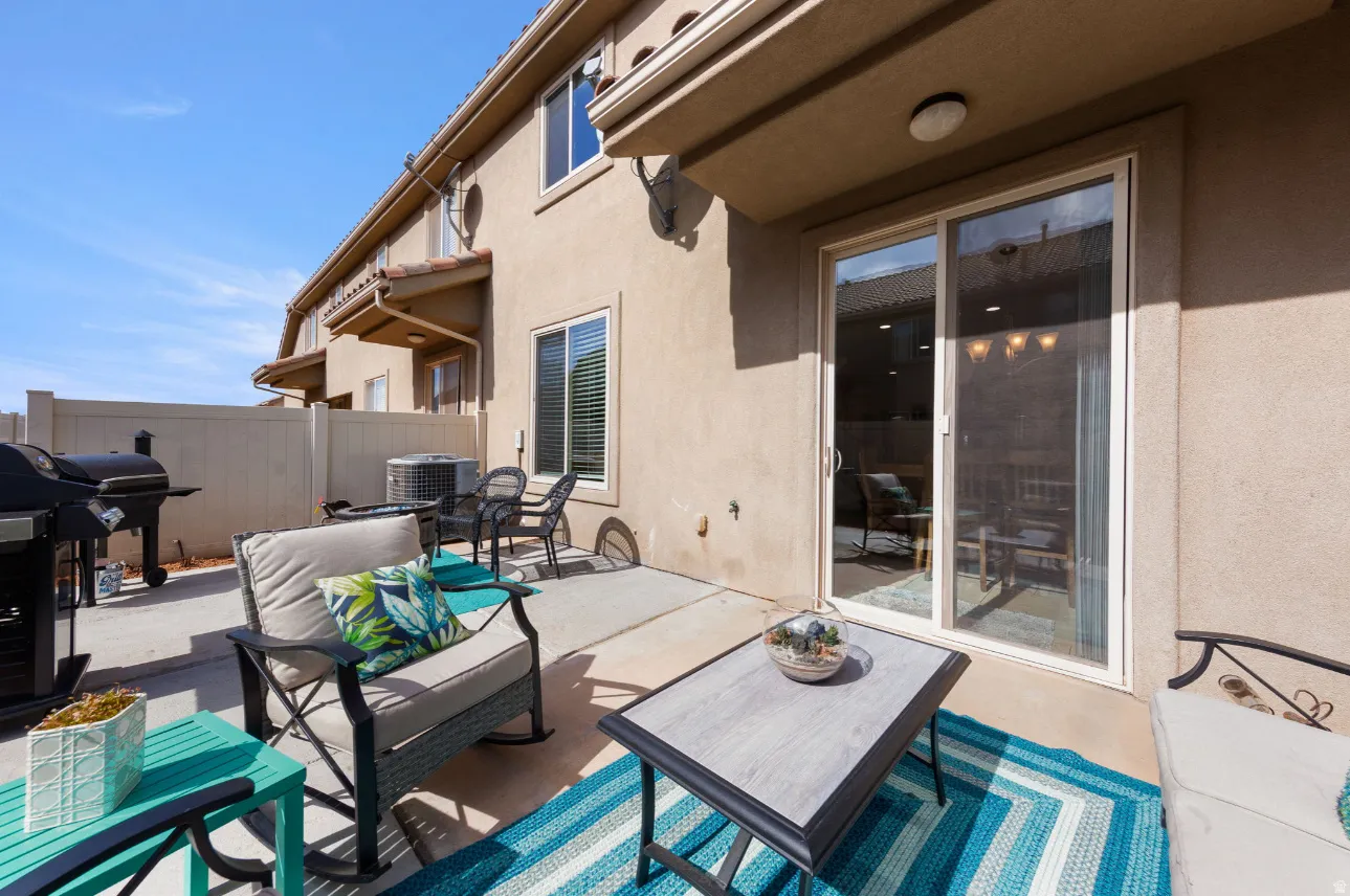 Private patio featuring a sliding glass door, stucco exterior, and privacy fencing