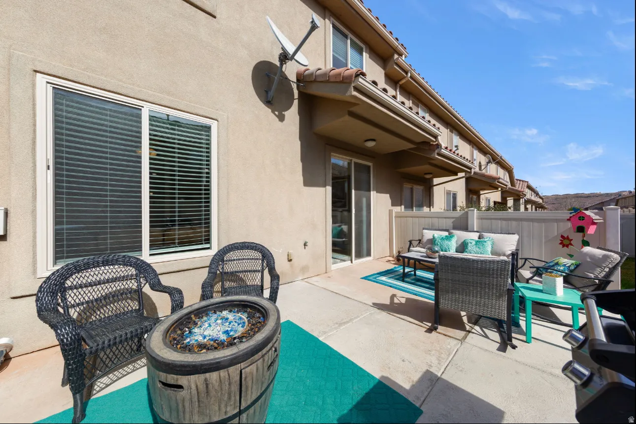 Private patio space featuring concrete surfacing and a privacy fence