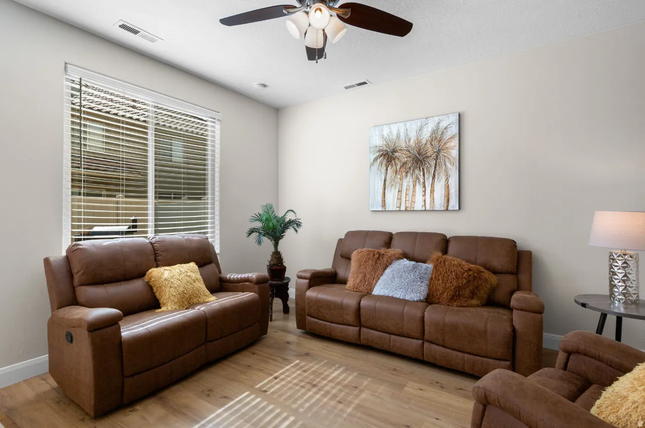 Light-toned wall paint with wood-finish flooring, recessed lighting, and a ceiling fan with integrated illumination