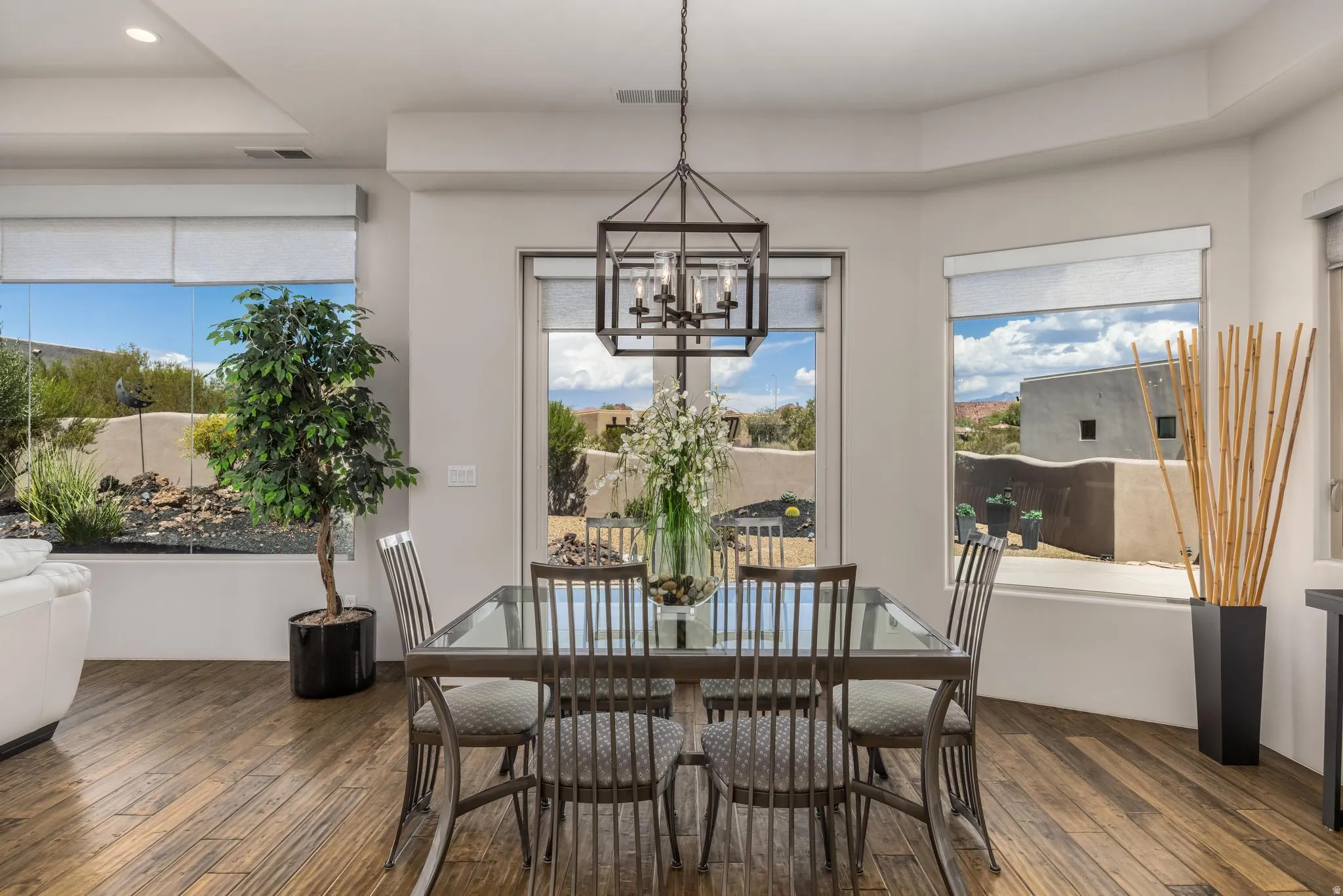 Dining area with wood-finish flooring, a contemporary chandelier, and a bay window configuration