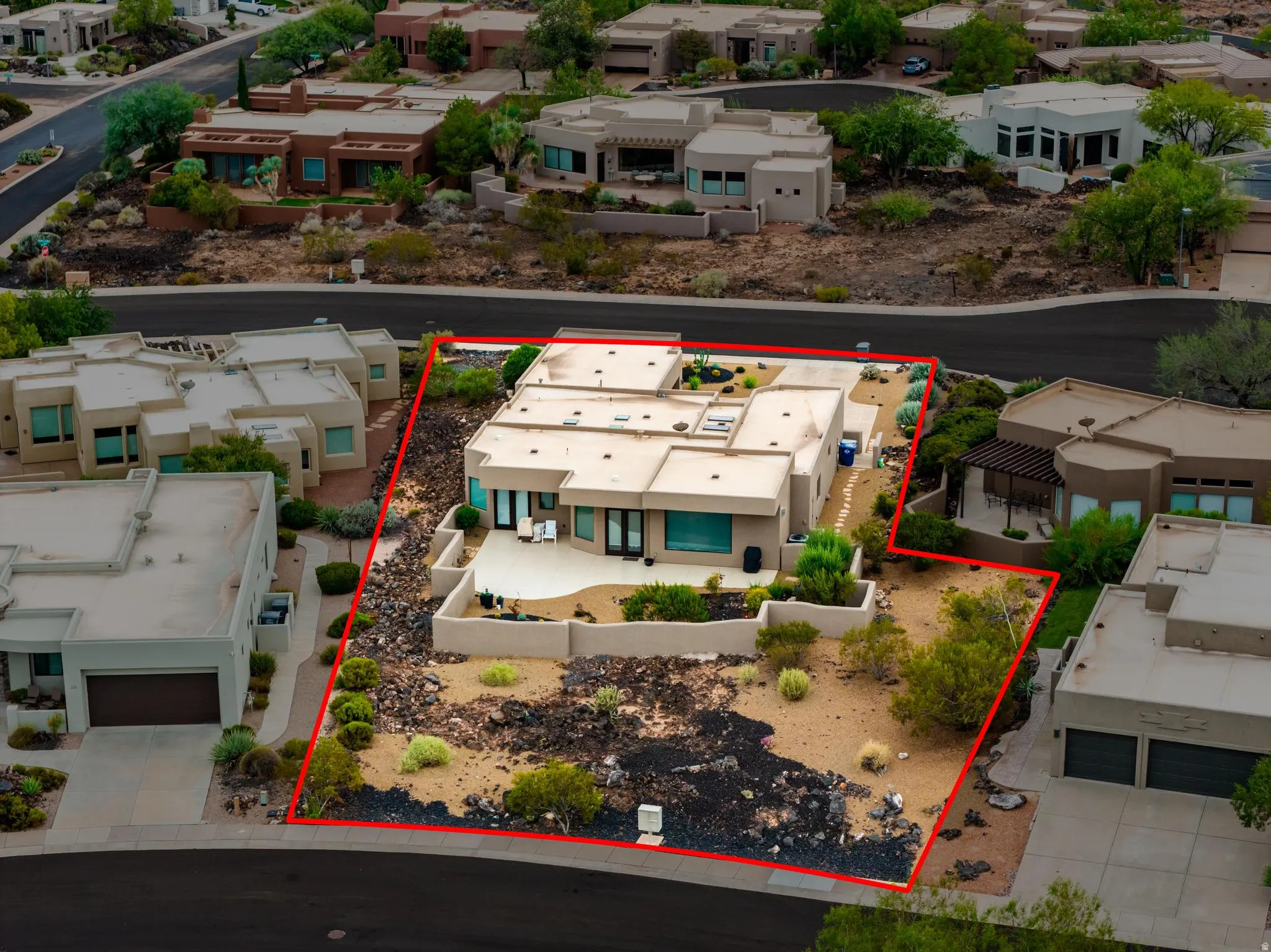 Contemporary stucco exterior with a flat roofline, integrated patio, and desert landscaping